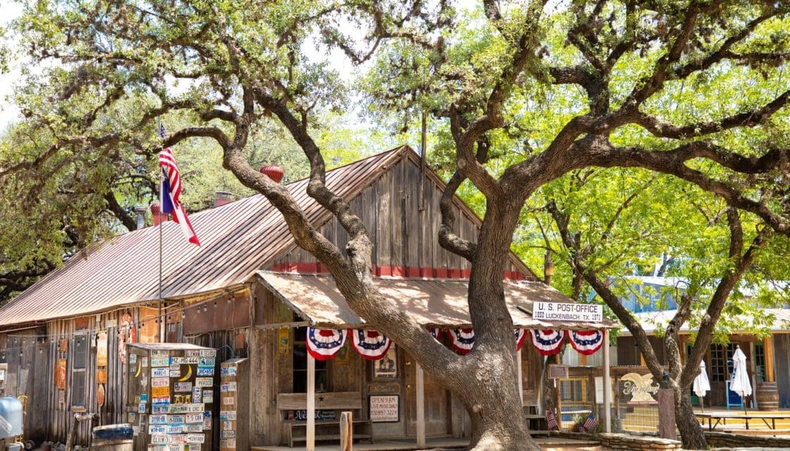 Gruene Texas with kids — rustic Texas Hill Country wooden post office with American flag and live oak tree