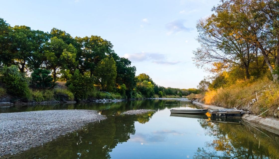 Marble Falls Texas with kids — serene lake at sunset with boat on glassy water