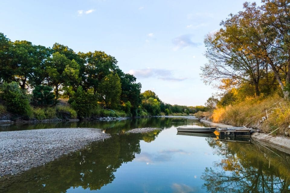 Marble Falls Texas with kids — serene lake at sunset with boat on glassy water